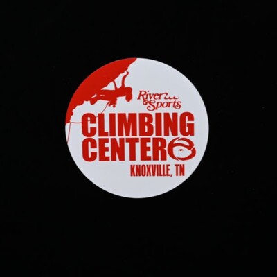 A circular sticker that is white with a red design of a rock climber that says 'Climbing Center - Knoxville, TN'