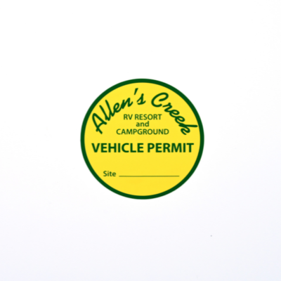 A circular sticker that is bright yellow with a green border and green text that reads 'Allen's Creek Vehicle Permit'