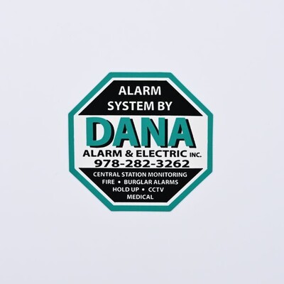 An octoganal sticker that's white and black with a teal border that reads 'DANA  Alarm & Electronic INC.'