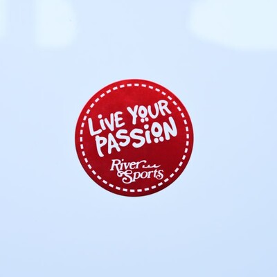 A circular sticker that is red with white text and a dotted border that says 'Live Your Passion'