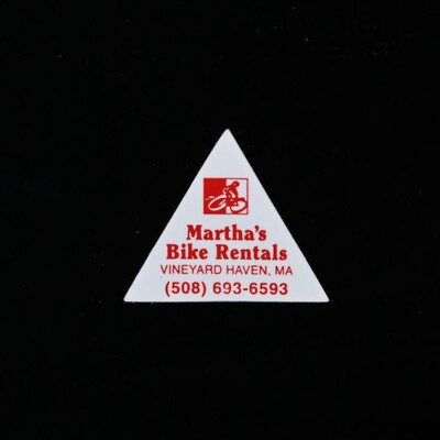A white triangular sticker with red text that says 'Martha's Bike Rentals'