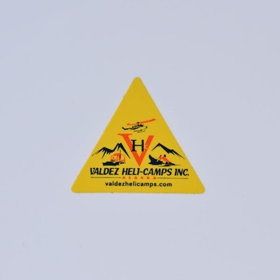 A yellow triangular sticker that says 'Valdez Heli-Camps INC.'